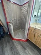 Bathroom containment separating the work area from nearby room surfaces.