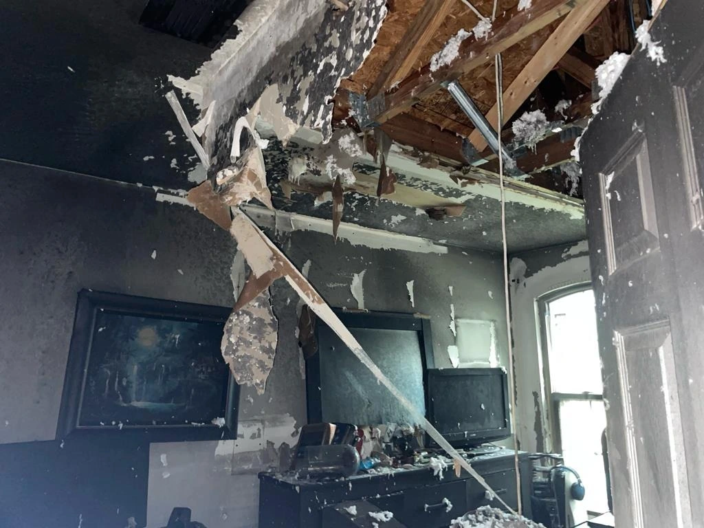 Construcción de cielo raso y pared dañada por el fuego dentro de la casa de dos plantas.