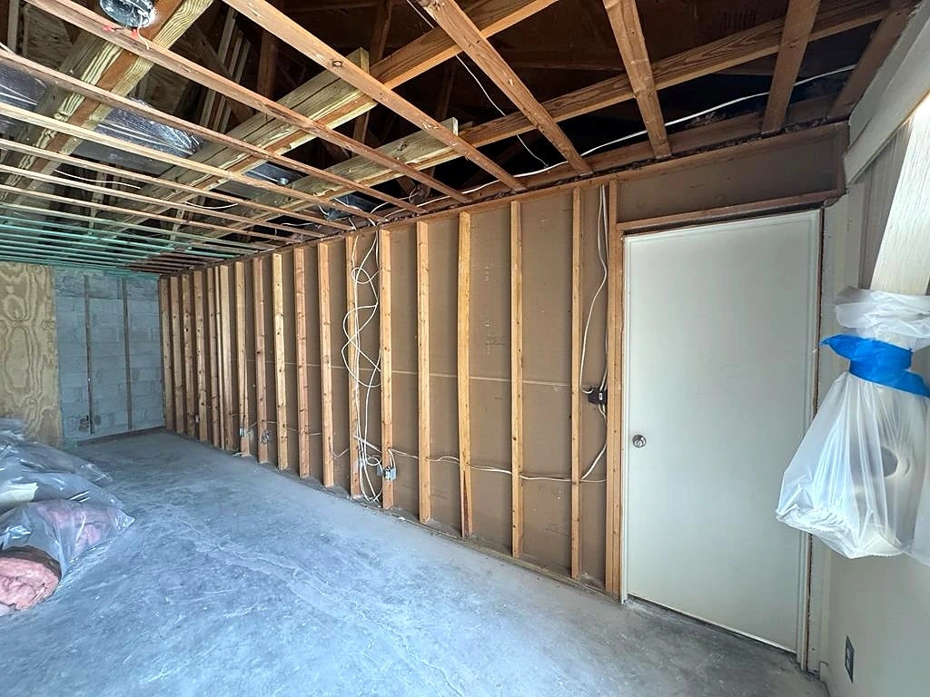 Exposed ceiling framing and wall studs during the remediation work.