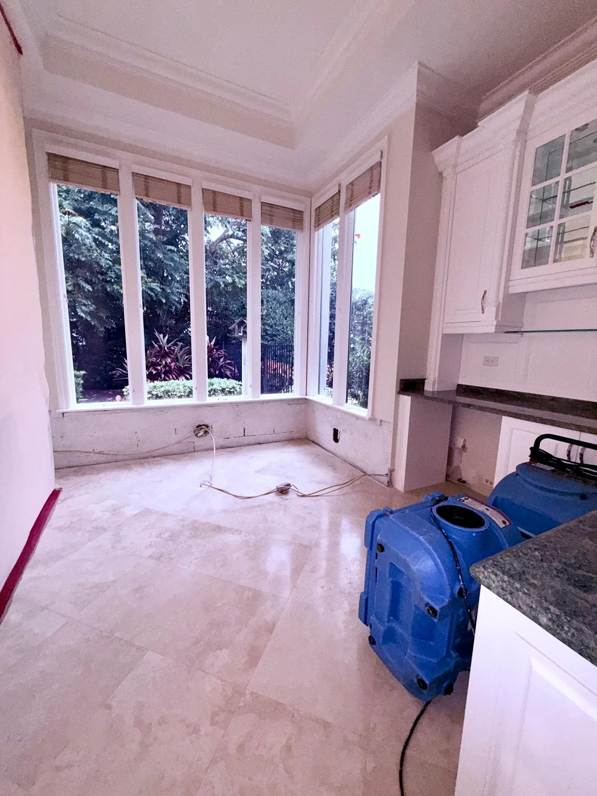 Air movers and drying equipment positioned beside removed flooring