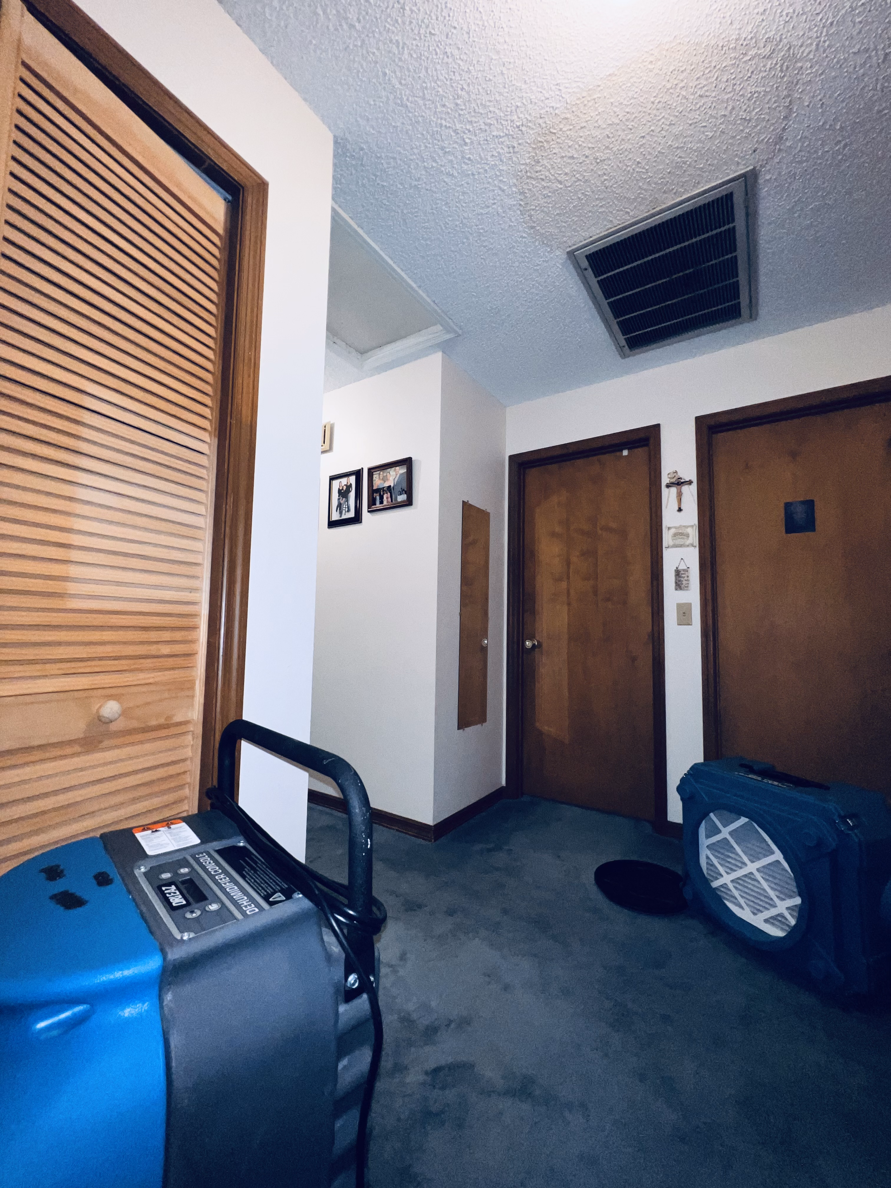 Drying equipment in a hallway beside doors and a drinking fountain