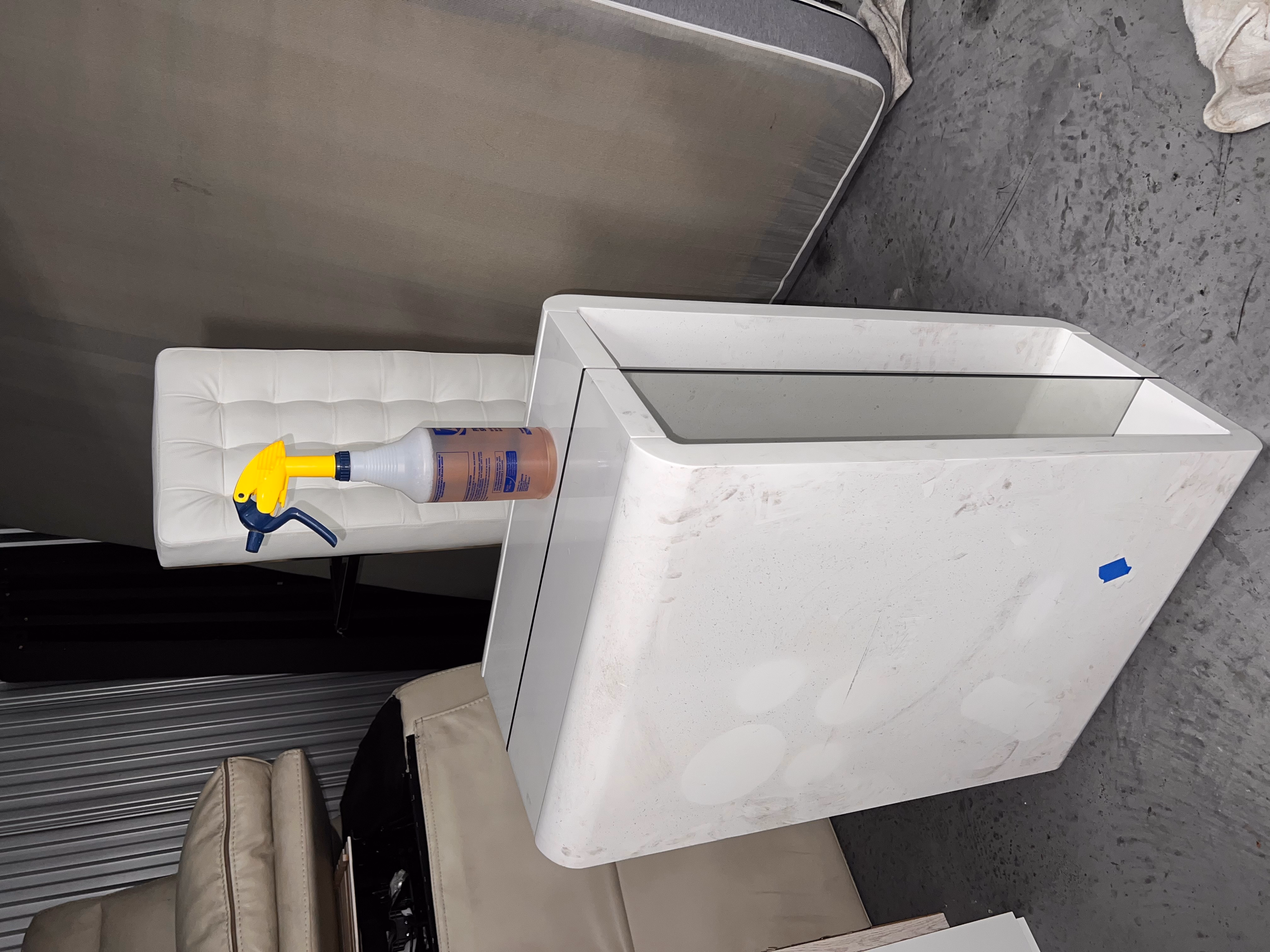 Productos de limpieza sobre un armario junto al refrigerador