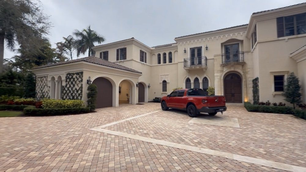 Large residential courtyard with a parked red vehicle