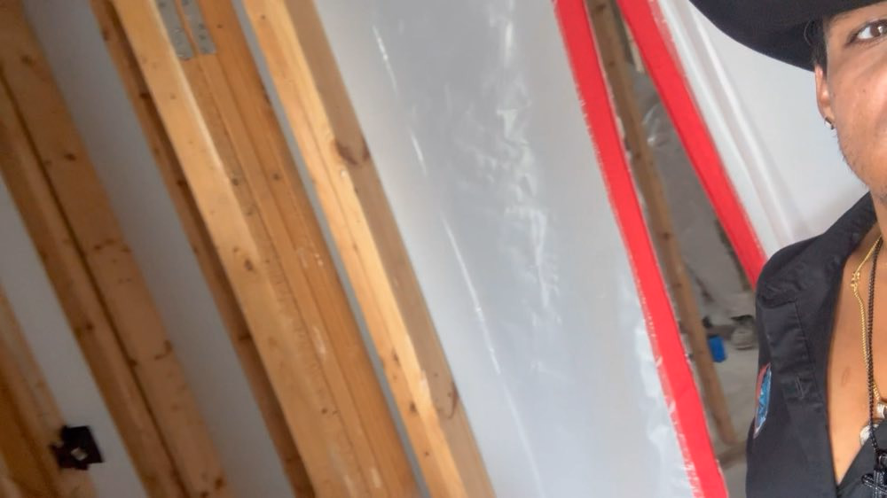 Team member beside a zippered containment entrance