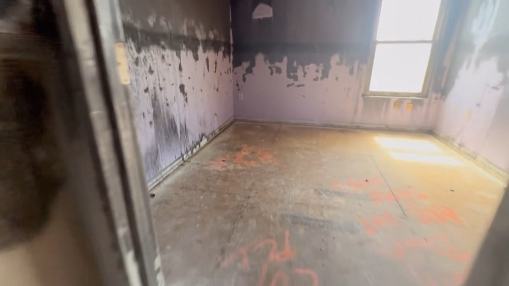 Stripped room with stained walls and a bare floor