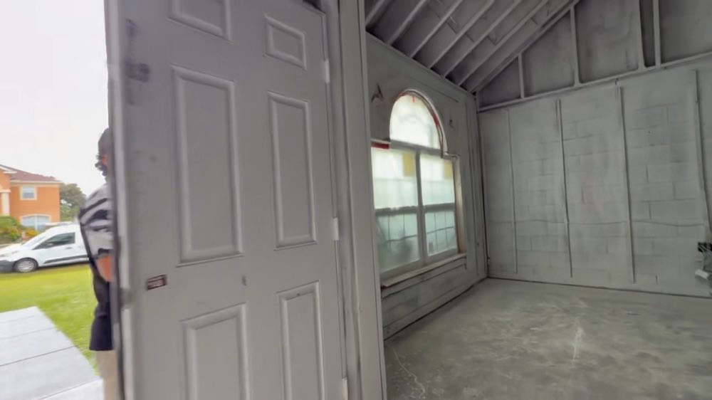 Open doorway into a room with exposed framing