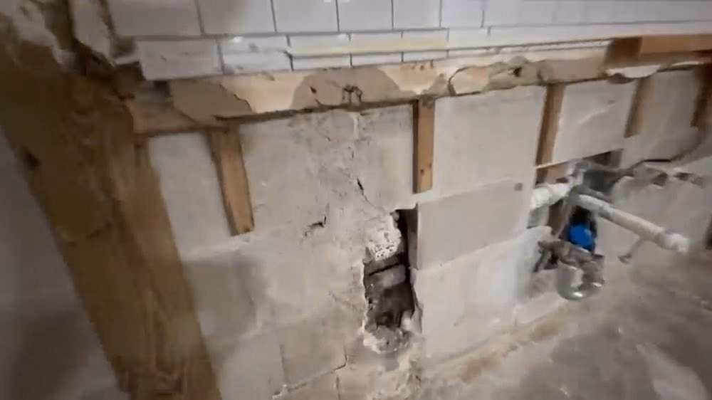 Plomberie exposée dans un mur de cuisine endommagé