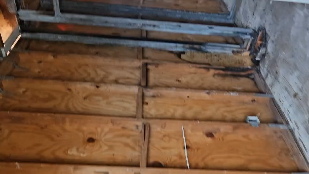 Estructura de madera y metal expuesta junto a una pared dañada