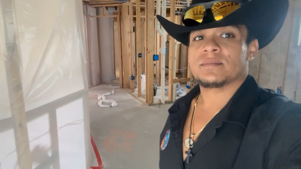 Hugo team member beside open framing and containment sheeting