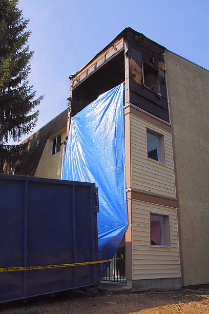 Temporary exterior covering protecting an opening in a fire-damaged building
